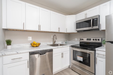 A kitchen with white cabinets and stainless steel appliances.