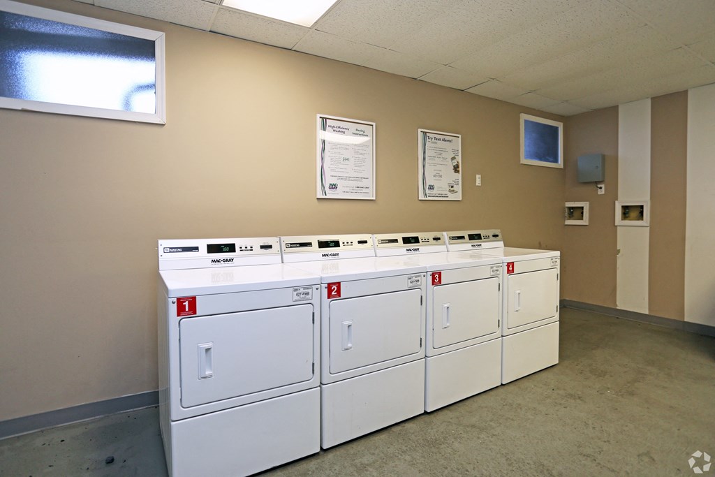 a row of white laundry machines in a room