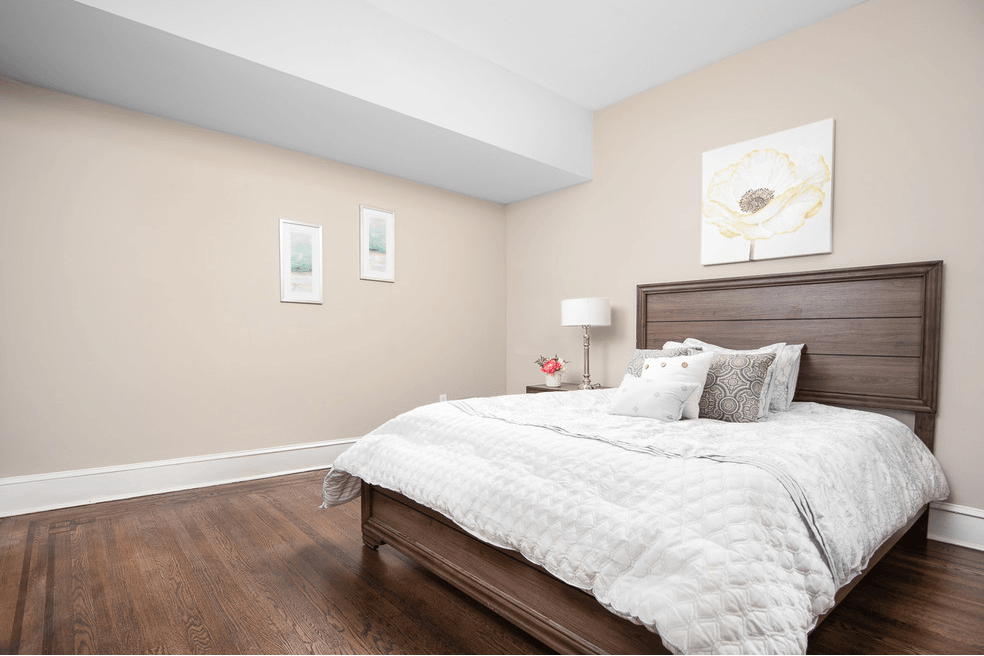 a bedroom with a bed and a wood floor