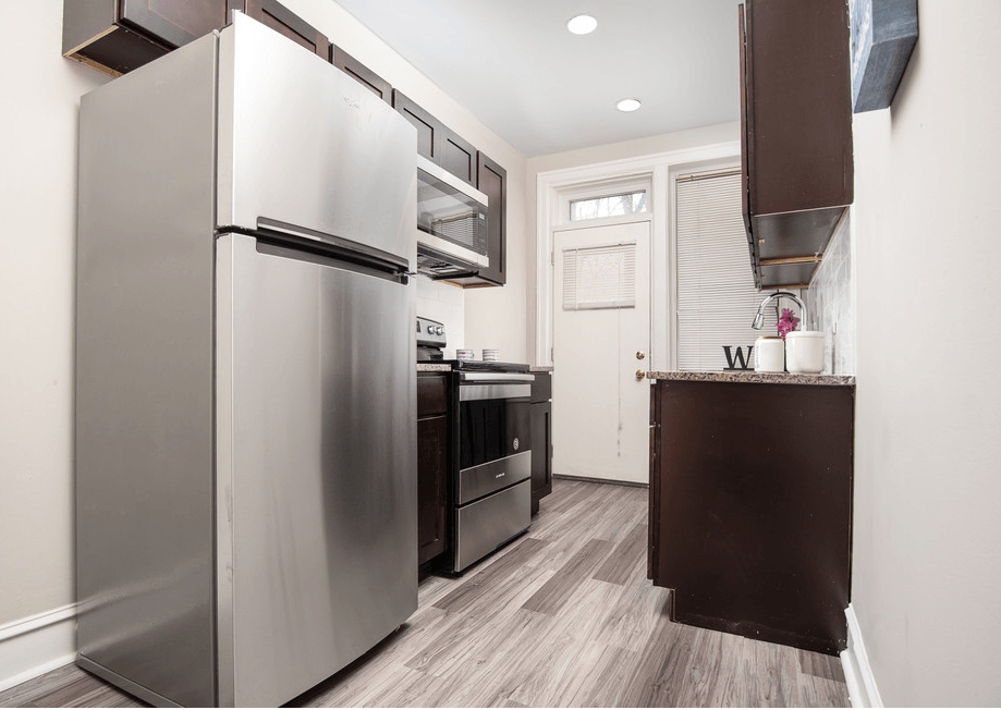 a kitchen with stainless steel appliances and a wooden floor