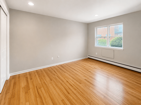 A room with wooden flooring and a window.