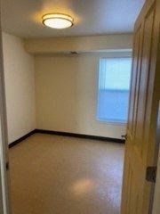 an empty room with a window and a door