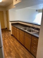 a kitchen with a sink and wooden floors