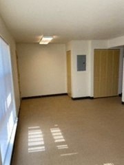 an empty room with a door and a window