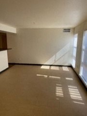 an empty living room with a kitchen and