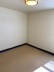an empty room with a white wall and a ceiling light