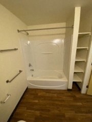 a bathroom with a toilet and shelves in it