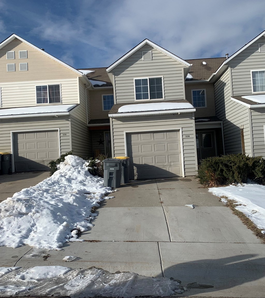 a driveway in front of a house with snow
