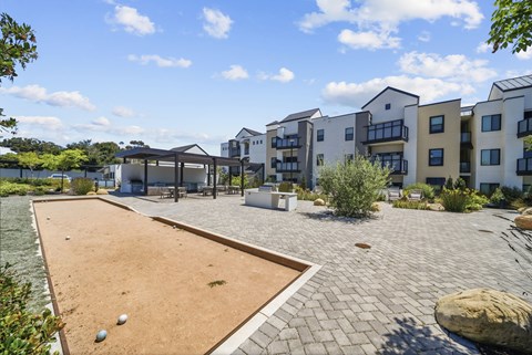 A residential area with apartment buildings and a sand volleyball court.