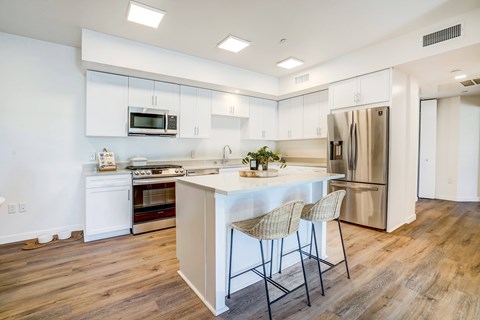 A kitchen with a white island and a refrigerator.