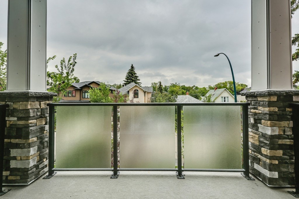 a balcony with a view of a neighborhood and a cloudy sky
