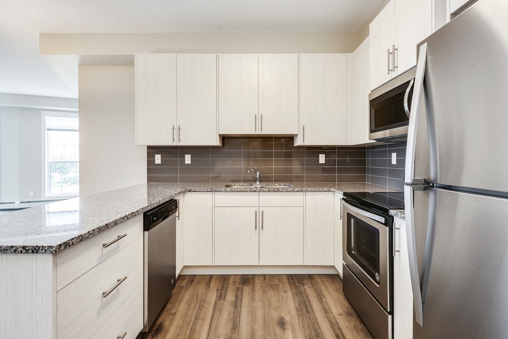 a kitchen with white cabinets and stainless steel appliances