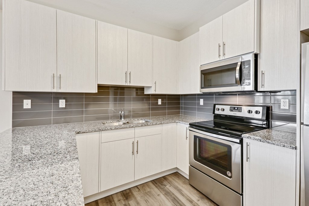 a kitchen with white cabinets and stainless steel appliances