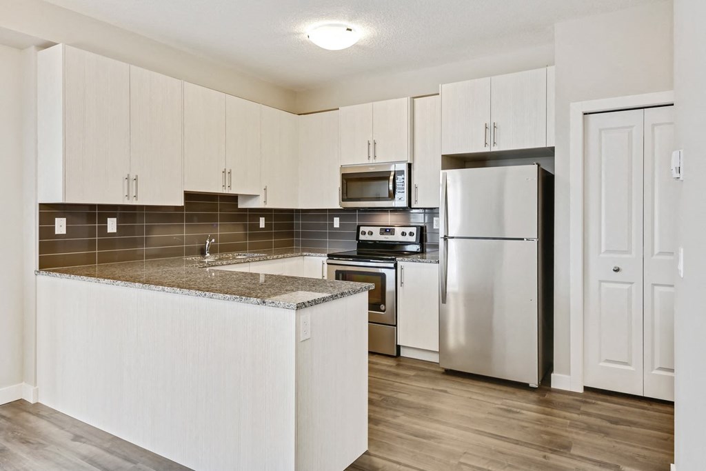 a kitchen with white cabinets and stainless steel appliances