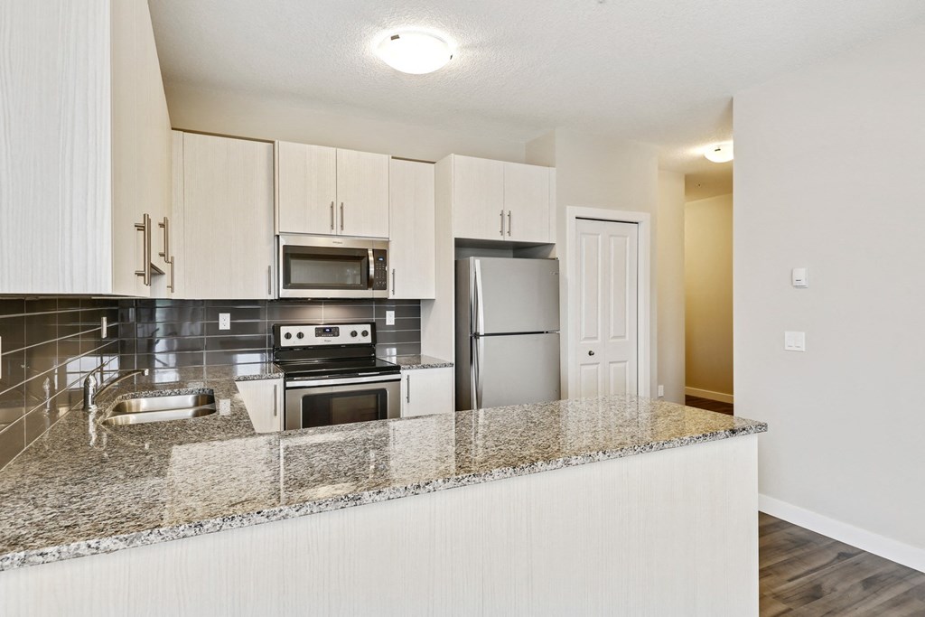 a kitchen with a granite counter top and a refrigerator
