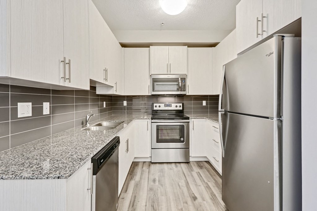 a kitchen with white cabinets and stainless steel appliances