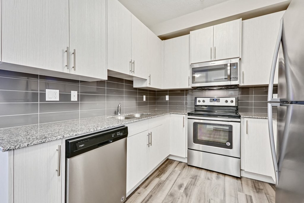 a kitchen with white cabinets and stainless steel appliances