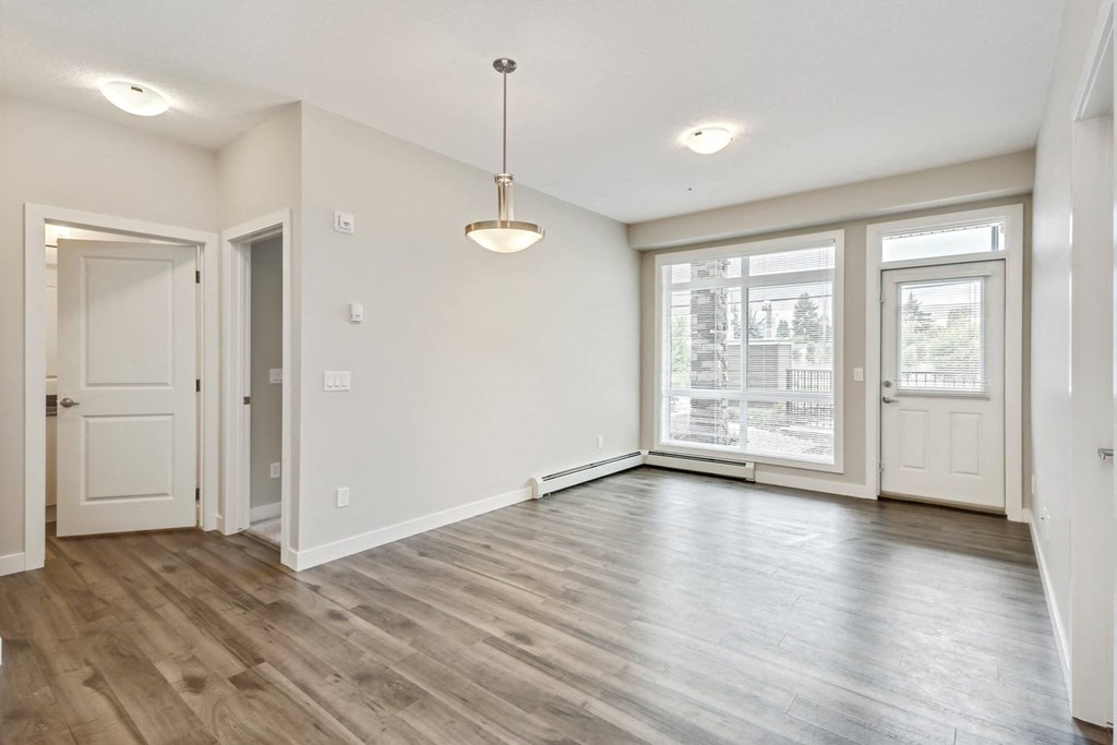 the living room and dining room of an empty home with a large window