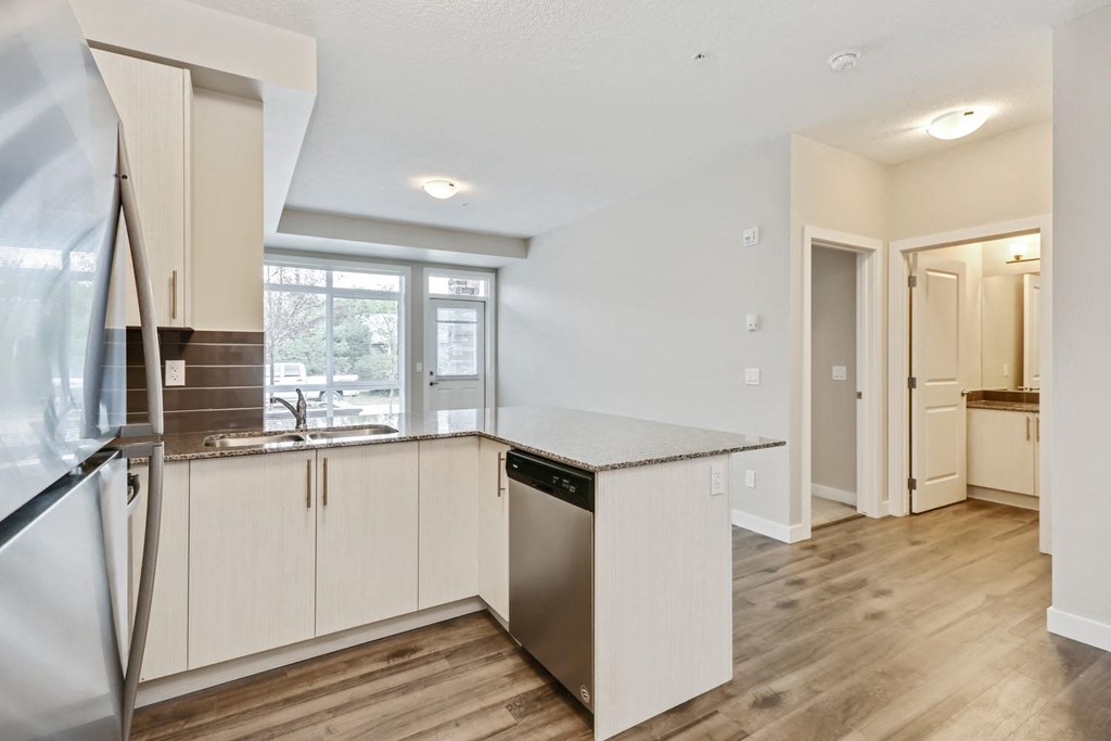 an empty kitchen with a refrigerator and a sink