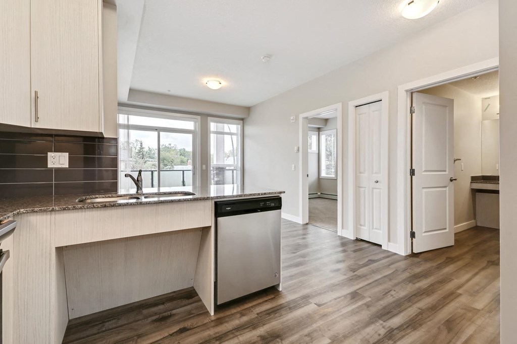an open kitchen and living room with a door to a hallway