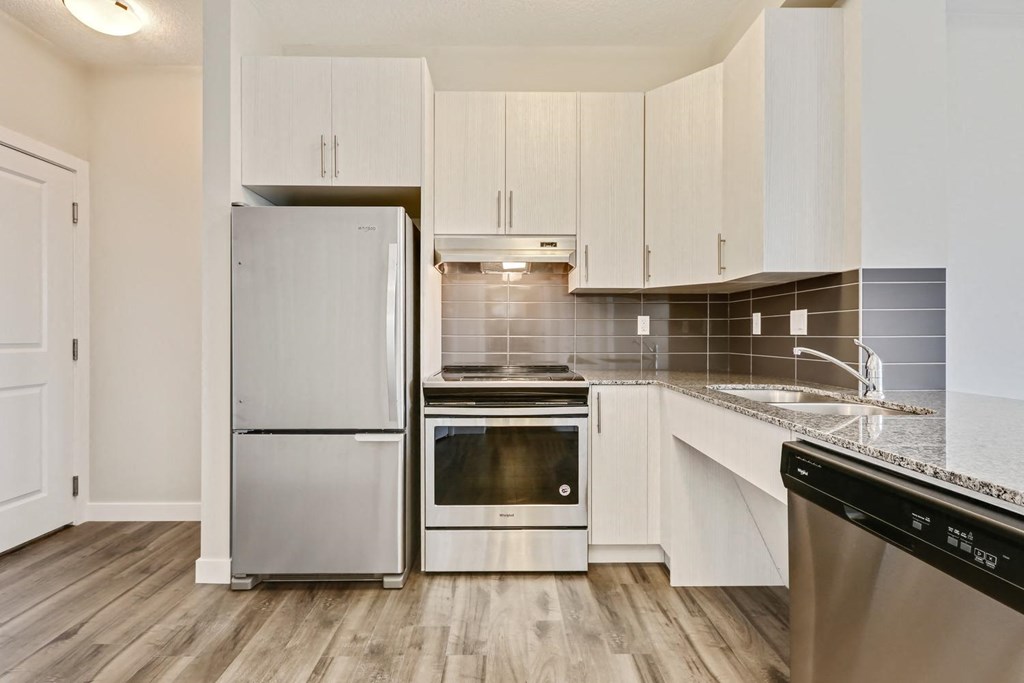 a kitchen with white cabinets and stainless steel appliances