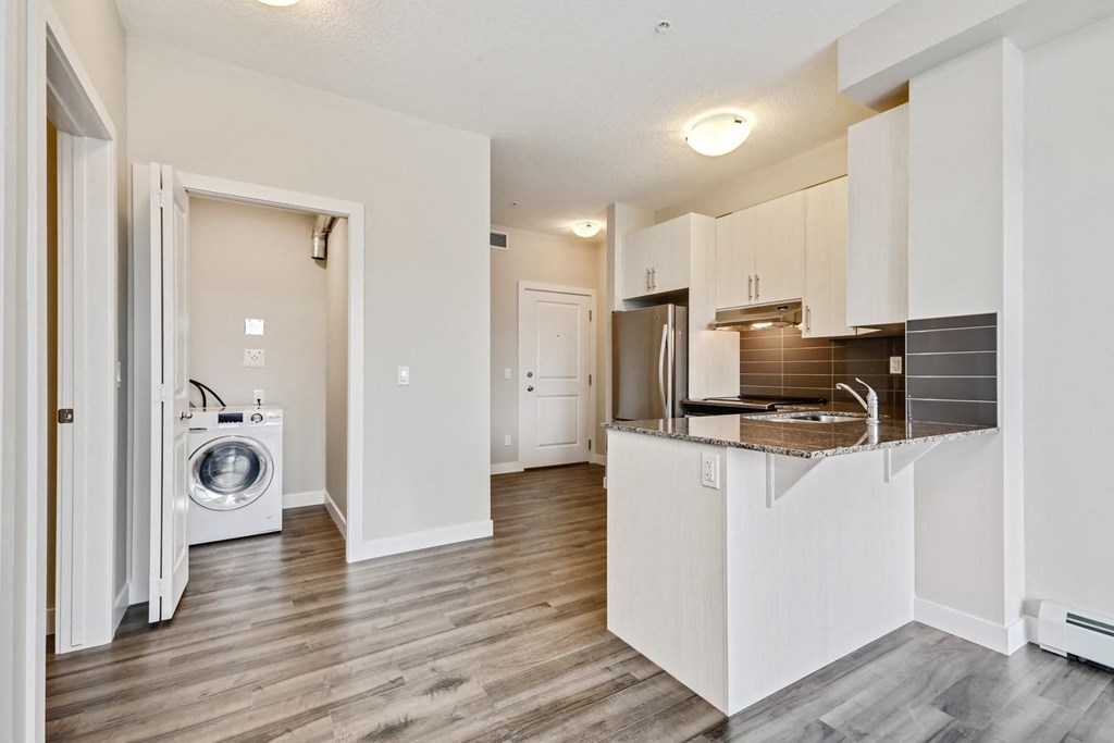 an open kitchen and laundry room with a washing machine