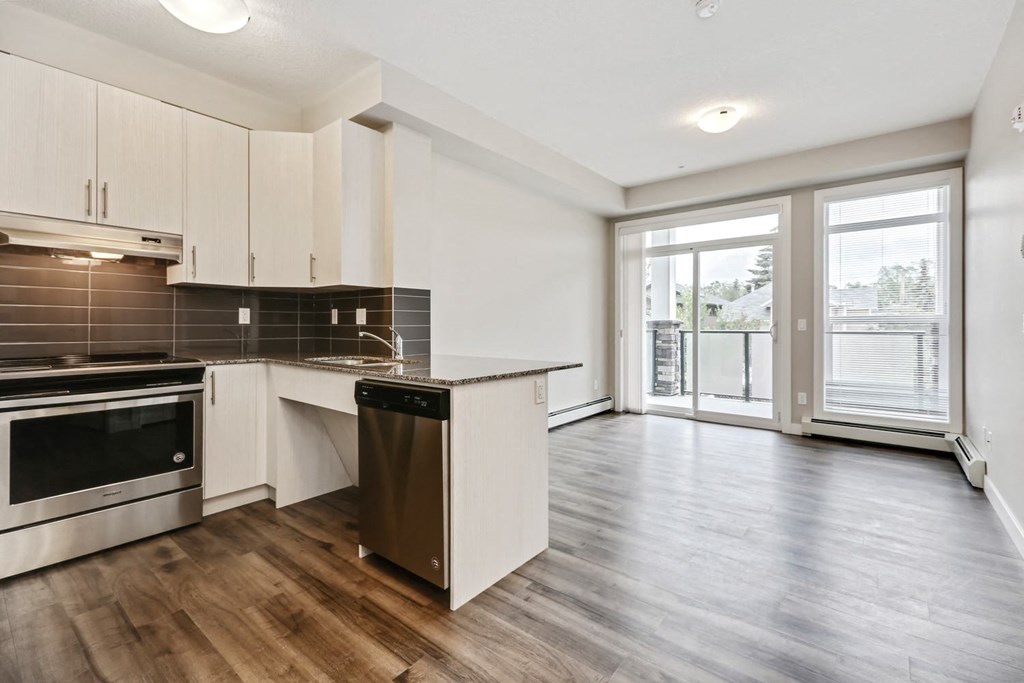 an empty kitchen and living room with a door to a balcony