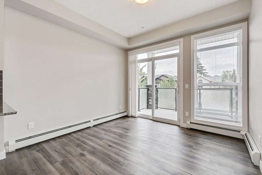 an empty living room with a large window and a balcony