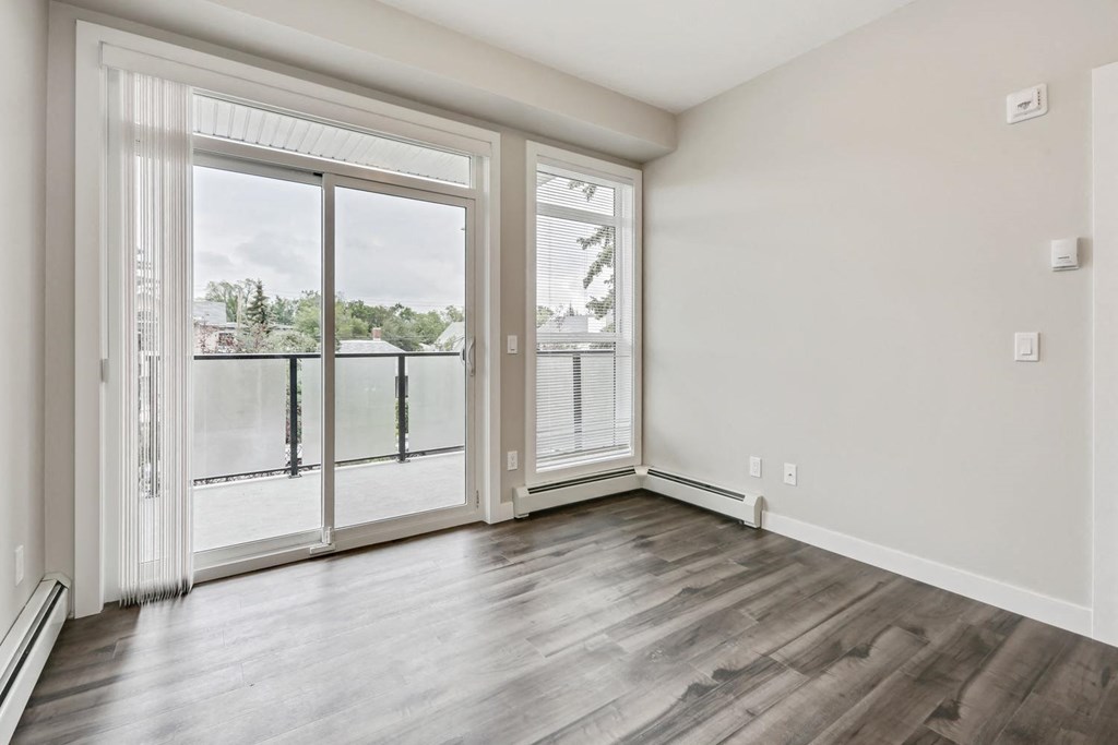 an empty living room with sliding glass doors to a balcony