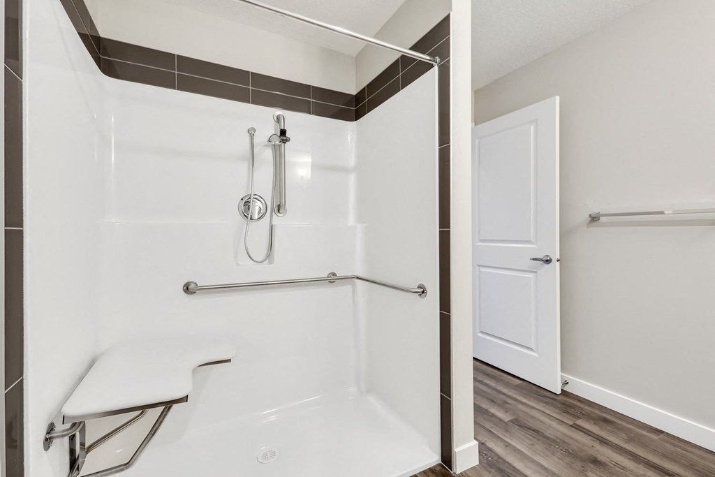 a white bathroom with a shower and a door