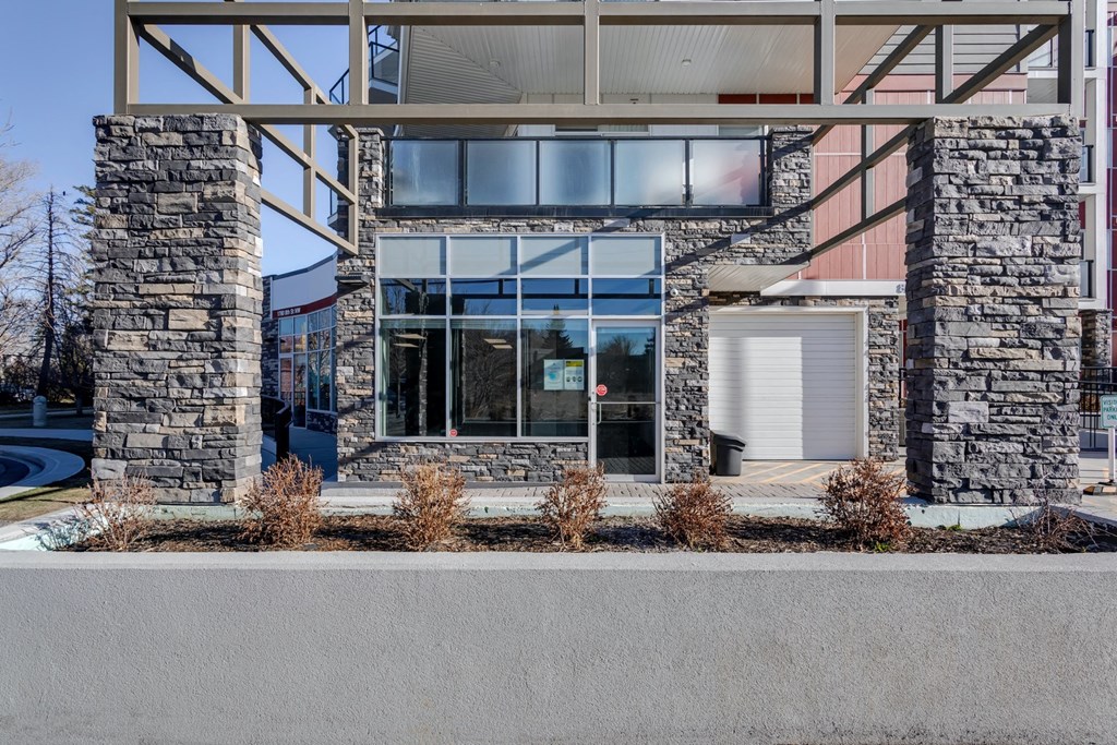 the front of a building with large windows and a sidewalk