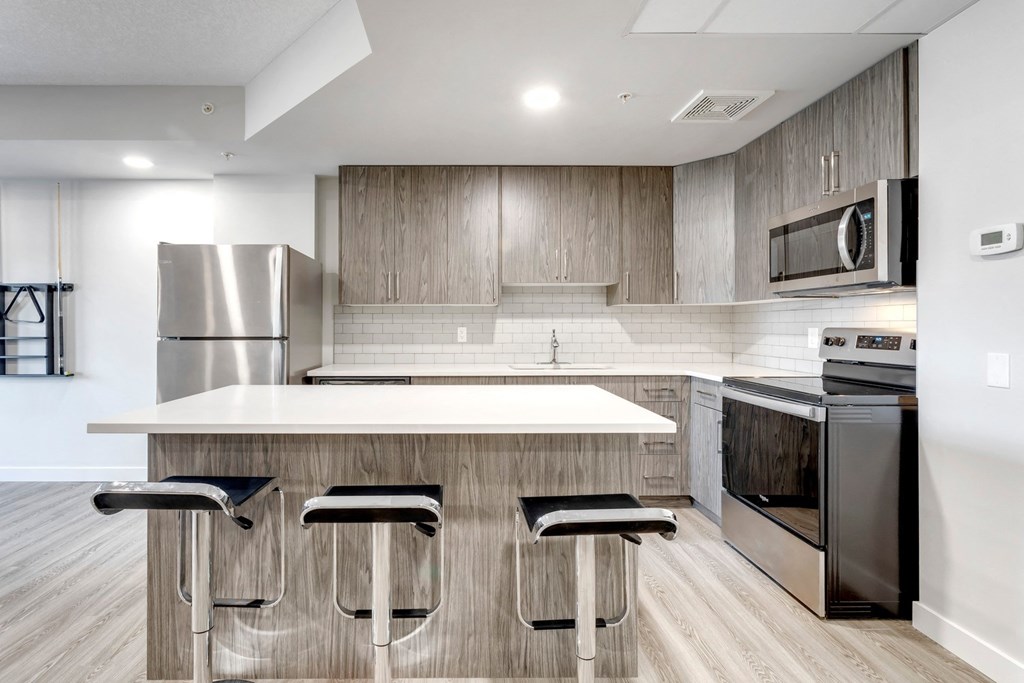a kitchen with a large island with three stools