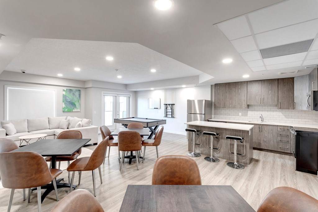 a clubhouse with tables and chairs and a kitchen and dining area