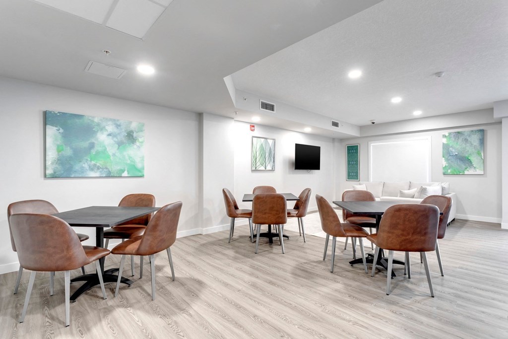 a dining room with tables and chairs and a tv