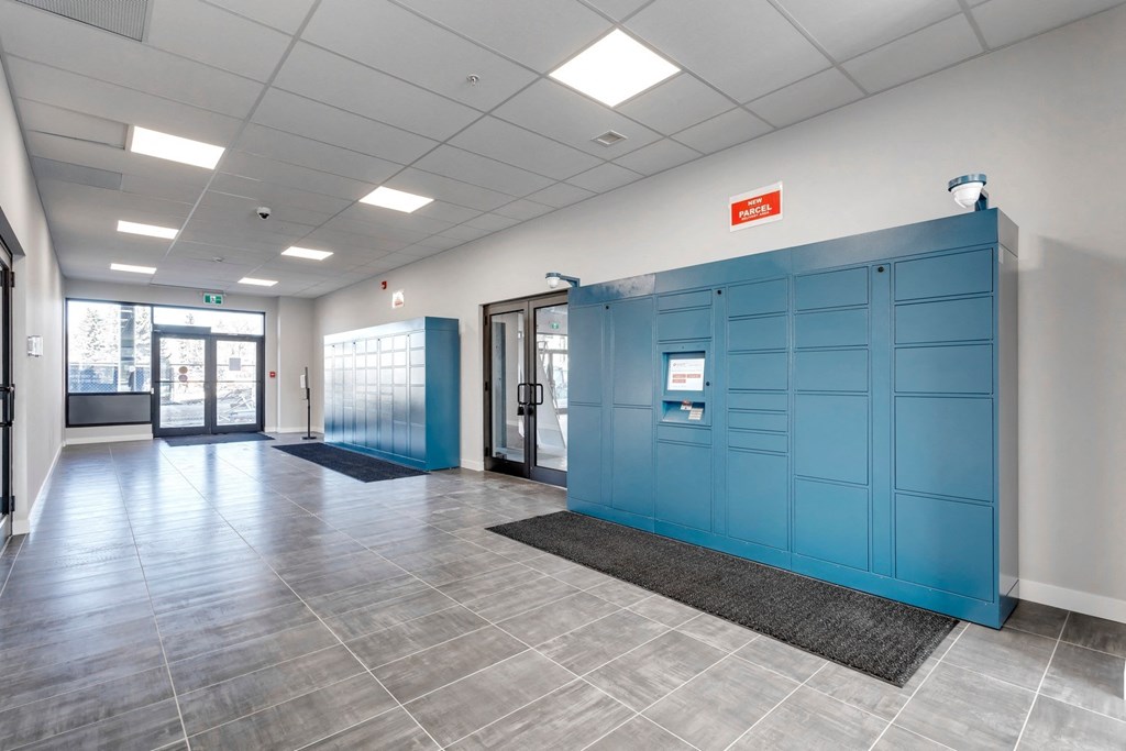 a hallway with blue lockers and doors in a building