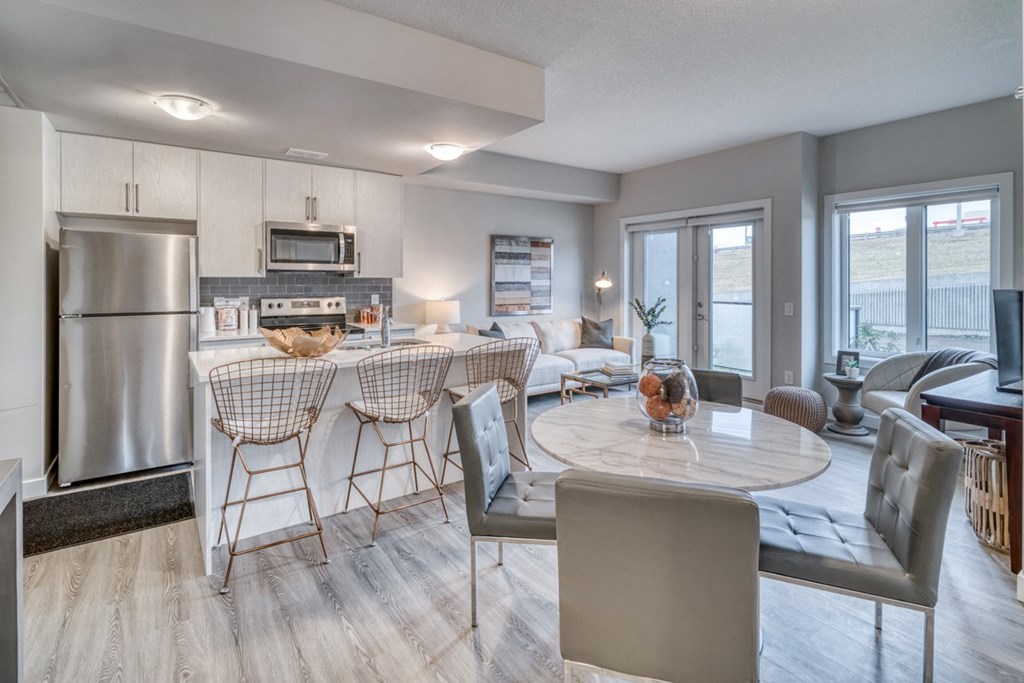 an open kitchen and living room with a table and chairs