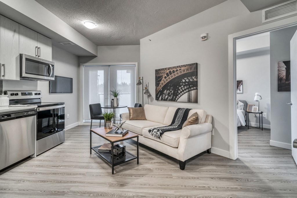 the living room of a studio apartment with a couch and a coffee table
