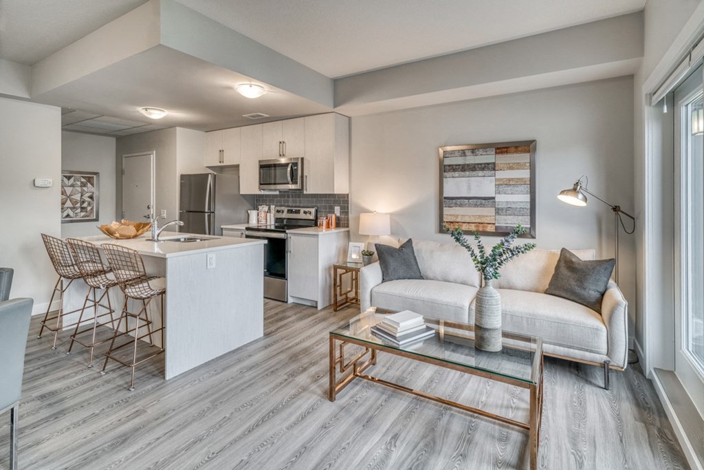 a living room with a couch and chairs and a kitchen