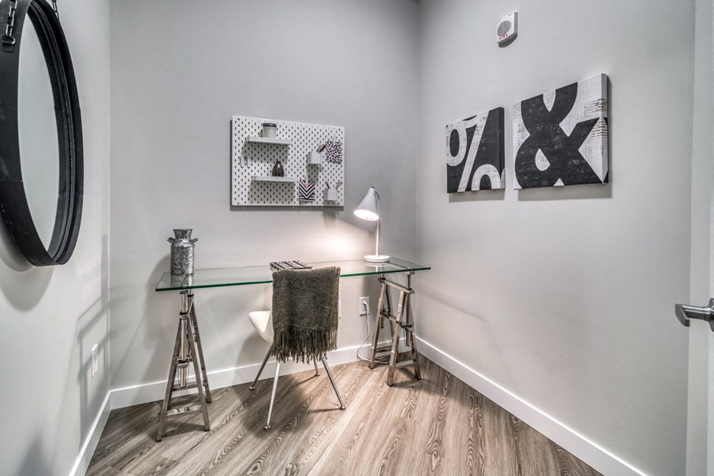 a home office with a glass desk and a chair