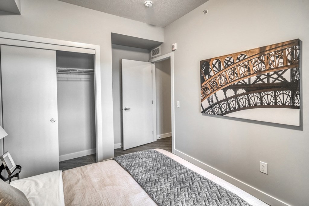 a bedroom with a bed and a painting on the wall