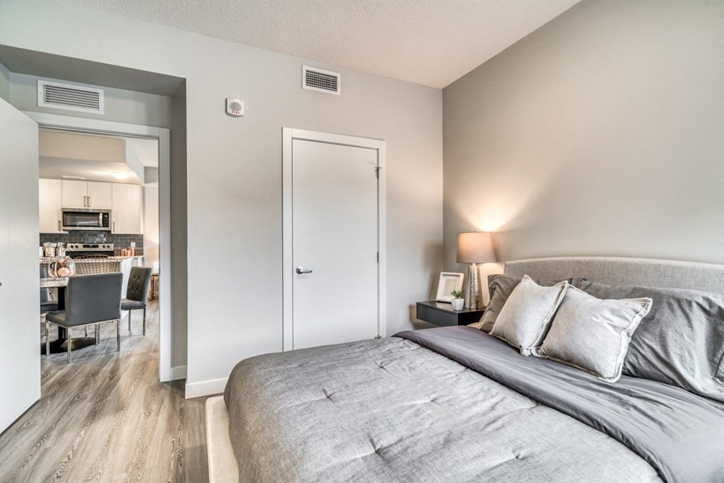 a bedroom with a bed and a living room with a kitchen