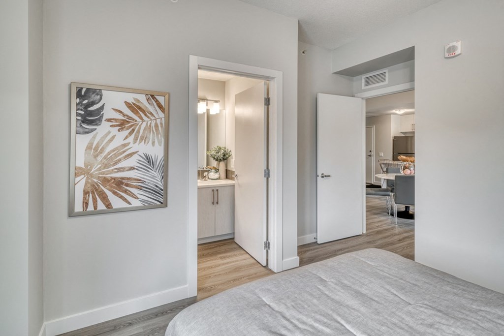 a bedroom with a view of the living room and the bedroom door to the bathroom