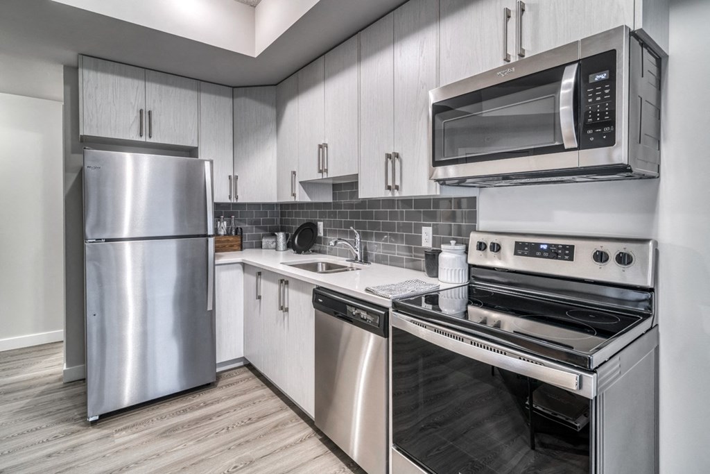 a kitchen with stainless steel appliances and white cabinets