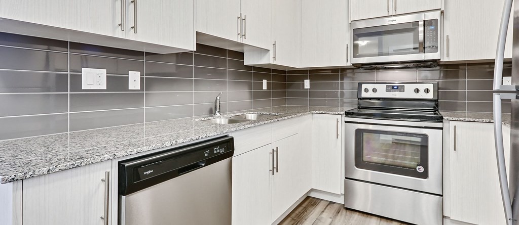 a kitchen with white cabinets and stainless steel appliances