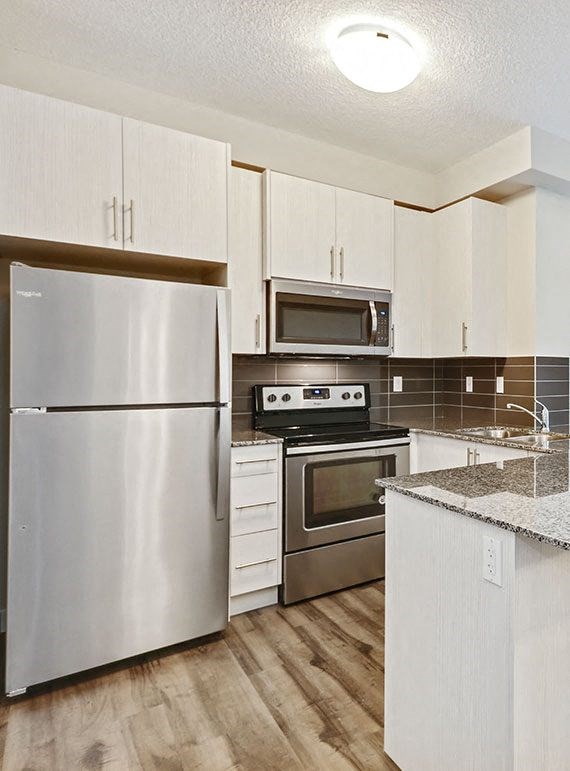 a kitchen with stainless steel appliances and white cabinets