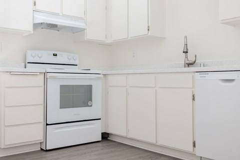 A white kitchen with a white oven and microwave.