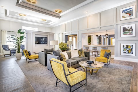 A living room with a yellow chair and grey couch.