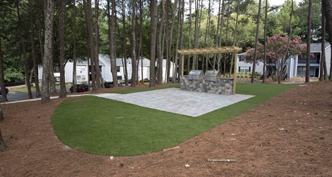 A park with a grassy area and a stone structure.