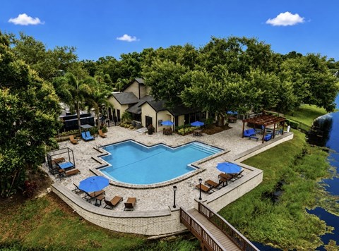 A large outdoor swimming pool surrounded by a deck and lounge chairs.