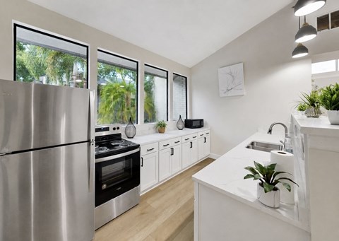 A modern kitchen with a stainless steel refrigerator and white cabinets.